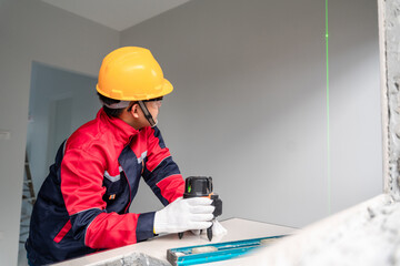 An engineer or construction worker  laser building level with green beams to measure the level inside the building. Construction and Repair or Renovation concept.