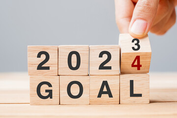 hand flipping block 2023 to 2024 GOAL text on table. Resolution, strategy, plan, motivation, reboot, business and New Year holiday concepts