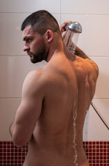 Sexy muscular man taking shower in bathroom. Sexy guy washing naked body. Male bodycare, beauty...