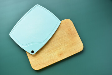 blue and brown wooden cutting board on green background, equipment for cooking in the kitchen