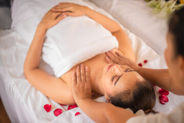 Fototapeta na wymiar Professional masseuse shoulder massage to beautiful asian woman on white bed.
