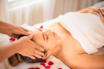 Obraz na płótnie Canvas As the massage continues the client on bed sprinkled with rose petals in spa room feels more and more at ease her worries and stresses melting away.