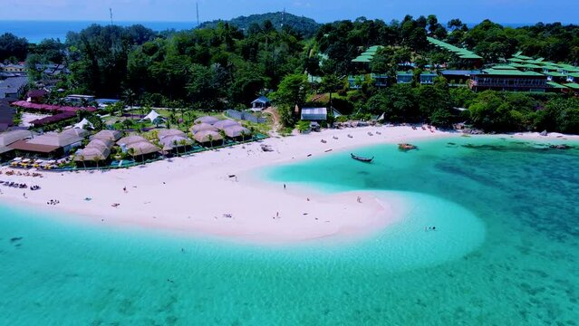 Couple on the beach of Koh Lipe Island Thailand, a tropical Island with a blue ocean and white soft sand. Ko Lipe Island Thailand. men and women relaxing on the beach looking out over ocean