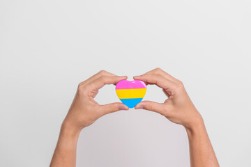 Pansexual Pride Day and LGBT pride month concept. hand holding pink, yellow and blue heart shape for Lesbian, Gay, Bisexual, Transgender, Queer and Pansexual community