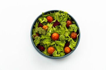 Green vegan salad from green leaves mix and vegetables. Top view on white background.