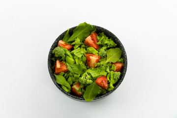 Green vegan salad from green leaves mix and vegetables. Top view on white background.