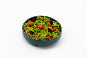 Green vegan salad from green leaves mix and vegetables on white background.