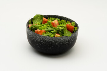 Green vegan salad from green leaves mix and vegetables on white background.
