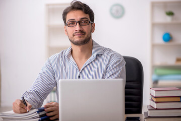 Young male employee student working in the office