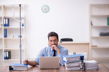 Young male employee suffering at workplace