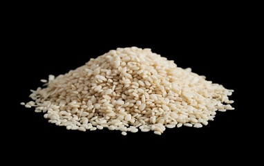 white sesame seed isolated on dark black background. pile of white sesame seed isolated on dark black background. heap of white sesame seed isolated on dark black background.