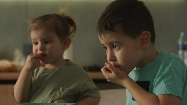 Two persons eating oranges while playing watching videos pn laptop, relaxing day at home concept. Family concept. People lifestyle concept. Modern lifestyle