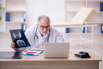 Obraz premium Old male doctor radiologist working in the clinic