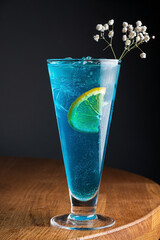Glass of Blue cocktail on the wooden background