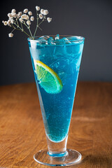 Glass of Blue cocktail on the wooden background