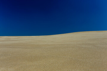 Minimalist sand background against blue sky