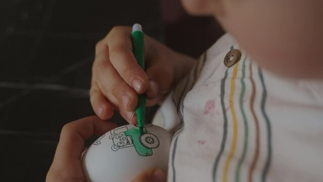 Kid celebrating Easter, painting eggs with brus preparing for the holiday. Festive decoration. Easter fun. Easter tradition. Family festive event. Happy easter.