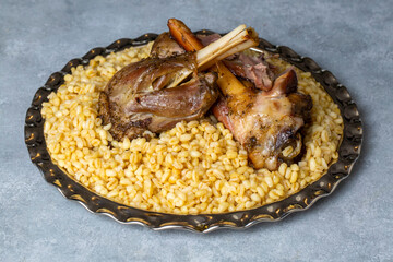 Turkish foods; lamb shank tandoori on bulgur wheat rice (Turkish name; bulgur bugday pilavi kuzu incik tandir)