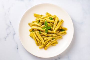 Casarecce pasta with cilantro pesto sauce on a grey background, top view. Delicious vegetarian lunch.