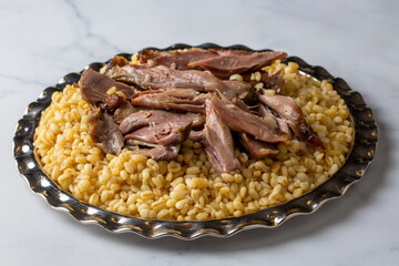 Turkish foods; lamb shank tandoori on bulgur wheat rice (Turkish name; bulgur bugday pilavi kuzu incik tandir)