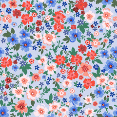 Seamless pattern. Vector flower design with cute wildflowers. Romantic abstract floral pattern on a blue background. Illustration of spring nature in bright red and blue tones.