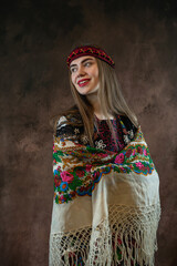 young ukrainian woman in national clothes, vyshyvanka and a headscarf, poses in the studio