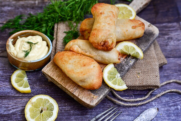   Allasca Pollock Fish  Bites in a crispy Tempura  Batter.Fish and chips .Close up of   crispy breaded  deep fried fish fingers with breadcrumbs s erved with remoulade sauce and  lemon