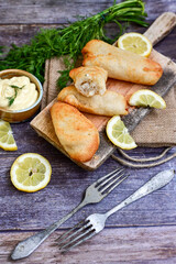   Allasca Pollock Fish  Bites in a crispy Tempura  Batter.Fish and chips .Close up of   crispy breaded  deep fried fish fingers with breadcrumbs s erved with remoulade sauce and  lemon