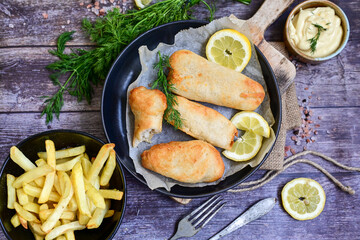   Allasca Pollock Fish  Bites in a crispy Tempura  Batter.Fish and chips .Close up of   crispy breaded  deep fried fish fingers with breadcrumbs s erved with remoulade sauce and  lemon
