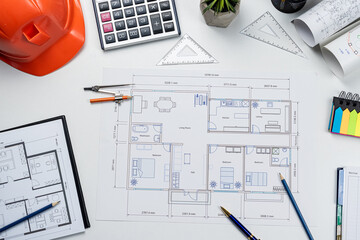 Housing project blueprints  with hardhat and tools on office workplace