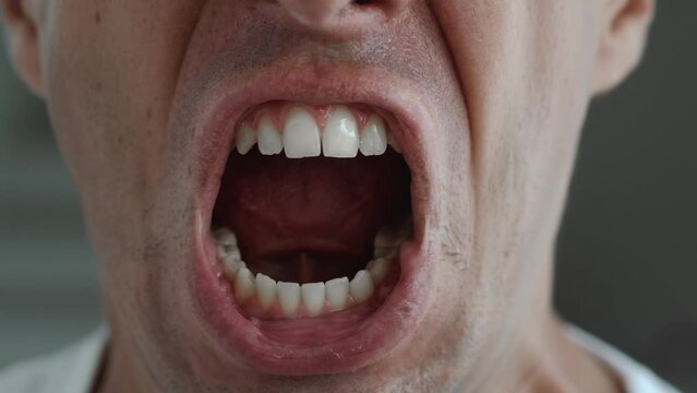 Shout, close up male face yelling or angry face expression. Close up mouth of angry man screaming and shouting, feeling anger and stress in bad mood.