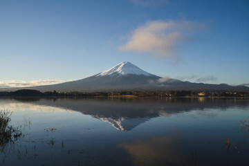 the landscape mountain in Japan fuji mountain reflects the Kawaguchi Lake surrounded by blue sky and snow on the top of the volcano, a beautiful view of the japan volcano on the sightseeing vacation