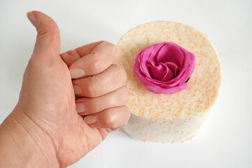 Hand show like on toilet papers and pink rose flowers background, Toilet paper with a smell concept, flat lay