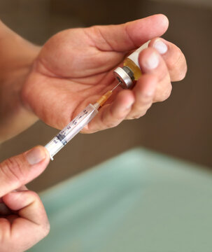 Filling a syringe, hands and clear liquid injection of testosterone and bottle, steroids and closeup of bodybuilder. Male athlete, grow strong muscles on hormone supplement and vial with needle
