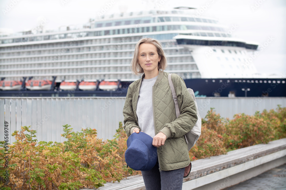 Wall mural woman tourist by the sea waiting for a cruise ship