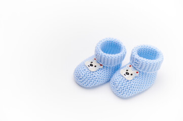 A pair of handmade blue knitted baby booties, isolated on white background. Newborn clothing and pregnancy concept. Copy space for advertising text. Fashion. Top view.