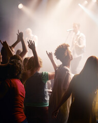 People dancing, concert and singing music at night performance, gen z band singer with lights and cheers. Musician on stage at event and youth dance, crowd of fans or women audience with hands in air