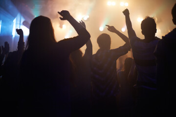 Lights, energy and people dancing at music festival from back, night and silhouette at live concert...