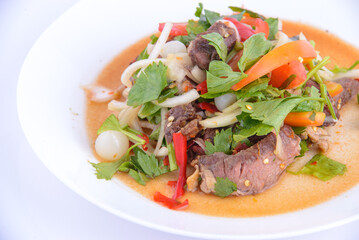 Favorite food of Thailand. Spicy grilled pork salad on the white background.