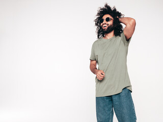 Handsome smiling hipster model. Unshaven Arabian man dressed in summer t-shirt and jeans clothes. Fashion male with long curly hairstyle isolated on white in studio. free space, mockup. Sunglasses