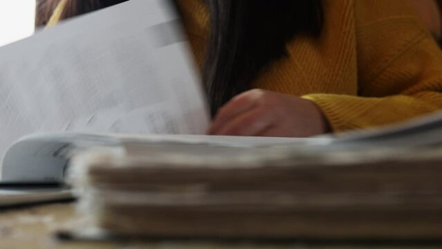 Female hands leaf through office book on table, closeup crop view. Woman read working papers, documentation. Paper work, reporting, audit, document specialist. Working lifestyle, office job.