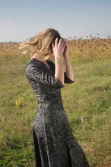 Serie of photos of female model in black and white pattern dress posing on meadow. Outdoor fashion portrait with natural light.