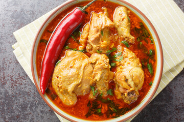 Chicken curry a Maharashtrian dish is made with aromatic Malvani spices and coconut closeup on the bowl on the table. Horizontal top view from above