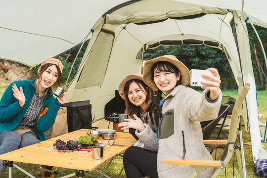 秋冬のアウトドア・キャンプ場にキャンプに来た女性達（女子キャンパー・友達・アジア人）

