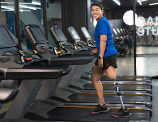Exercise Asia woman with prosthetic leg and walk in treadmill at gym or fitness