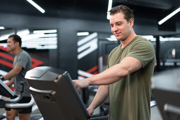 Fototapeta na wymiar Caucasian man with exercise machine at fitness gym 