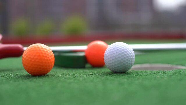 Close-up of miniature golf hole with bat and ball