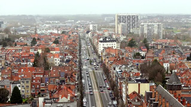 A zoomed in video of a busy street in Brussels, Belgium from a top down view. The camera captures the houses, buildings and cars moving along the road. A lively footage for urban or traffic themes.