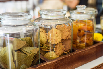 Jar full of circle homemade cookies, cones and dried fruits with copy space