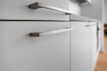 Fototapeta na wymiar White counter with handles in modern kitchen, closeup